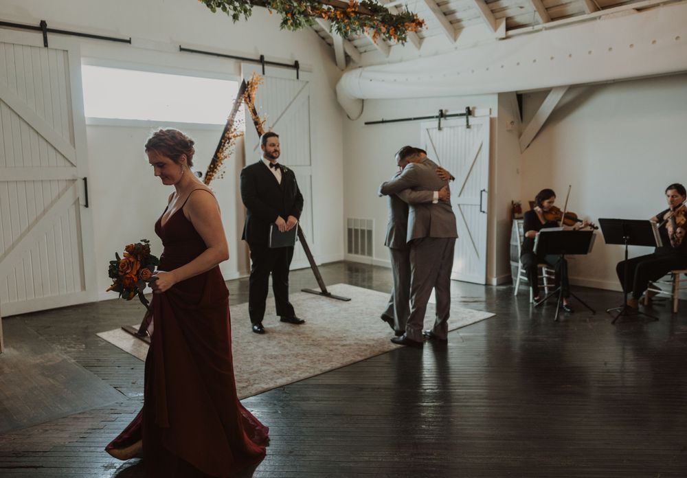 Wedding ceremony space with dark hardwood floors and white vaulted ceilings.