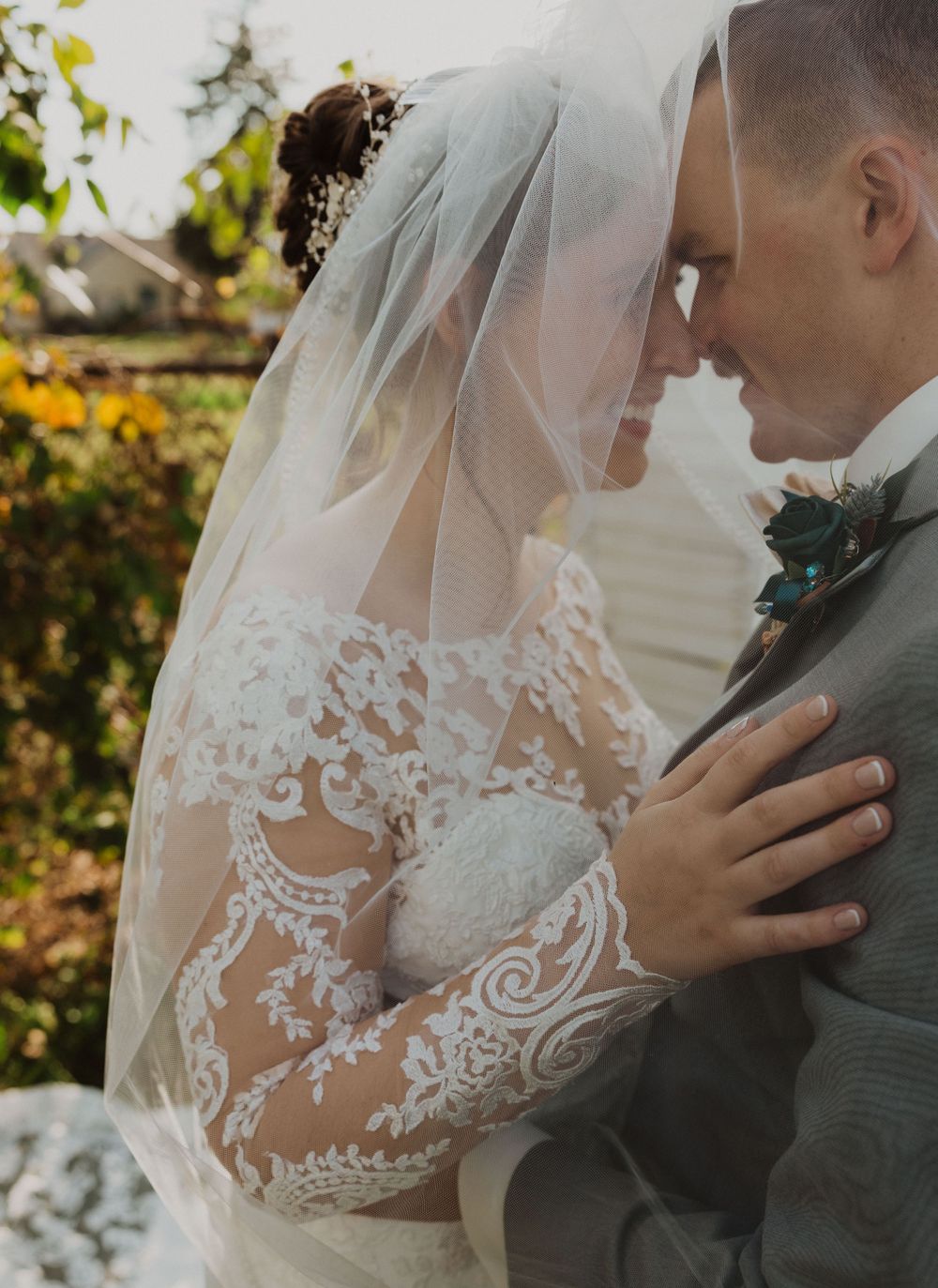 Close-up wedding portrait showcases delicate veil and lace dress details.