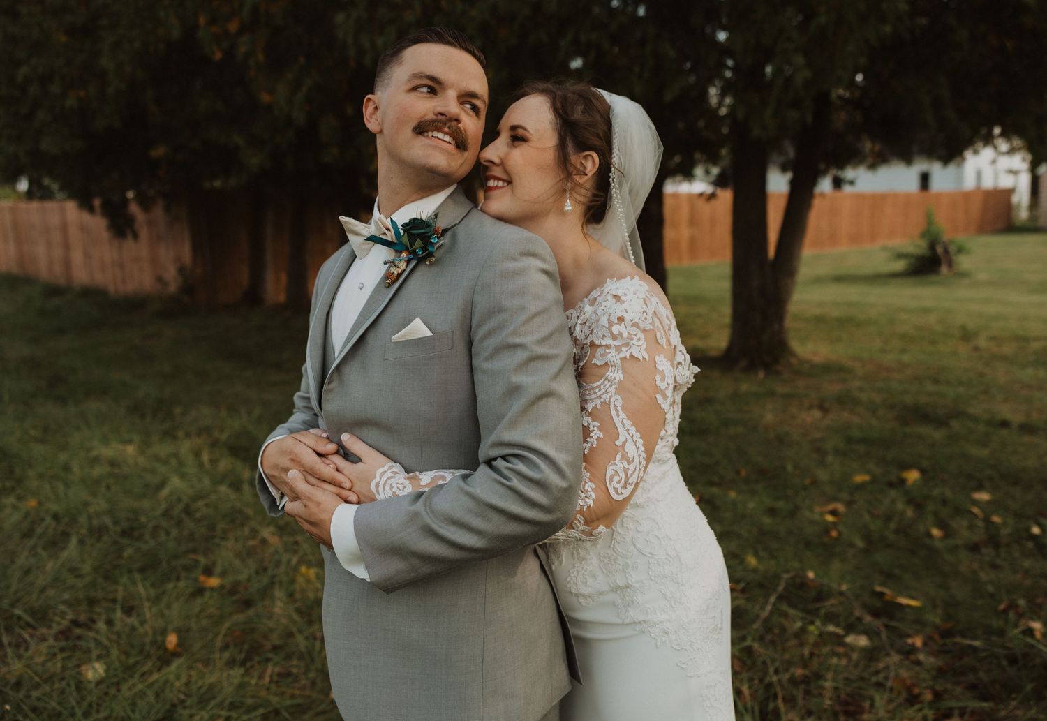 Intimate wedding portrait captured in a natural outdoor setting with fall foliage.