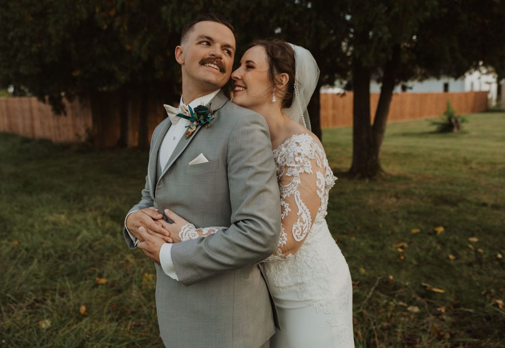 Intimate wedding portrait captured in a natural outdoor setting with fall foliage.