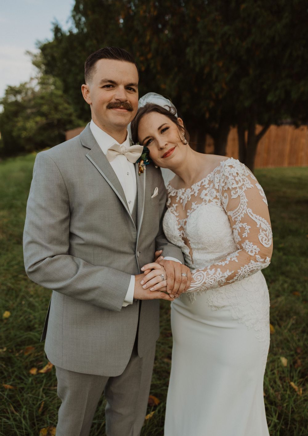 Romantic outdoor wedding portraits captured against a backdrop of trees at golden hour.