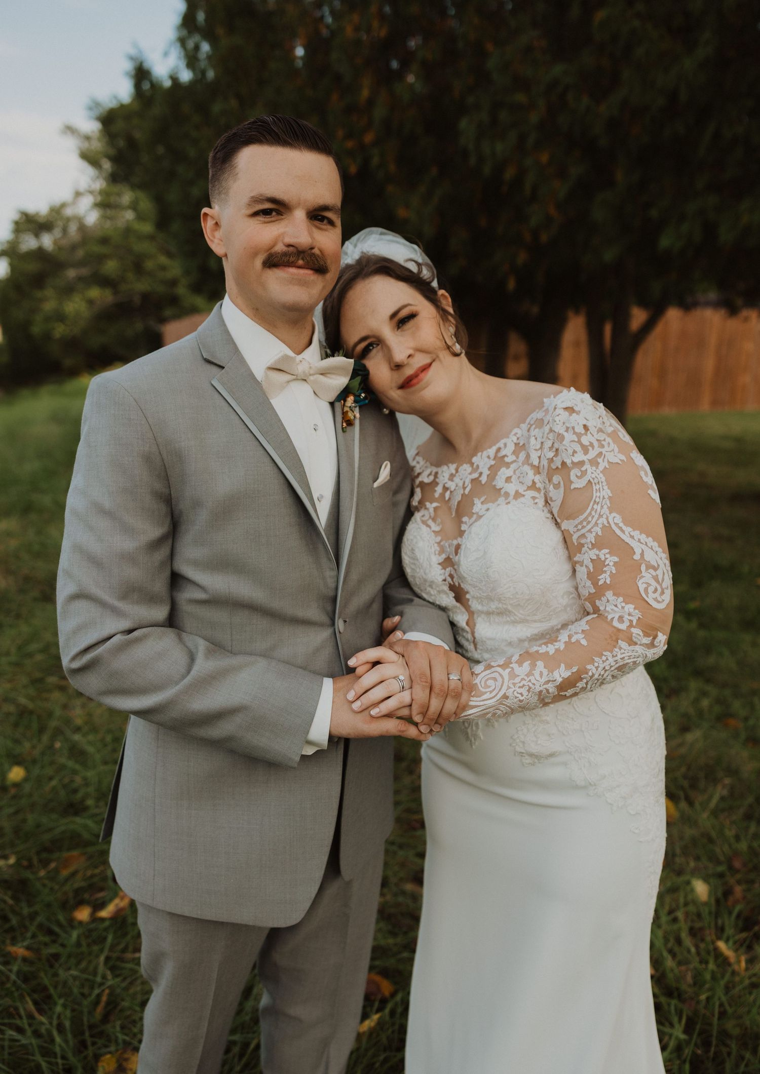Romantic outdoor wedding portraits captured against a backdrop of trees at golden hour.