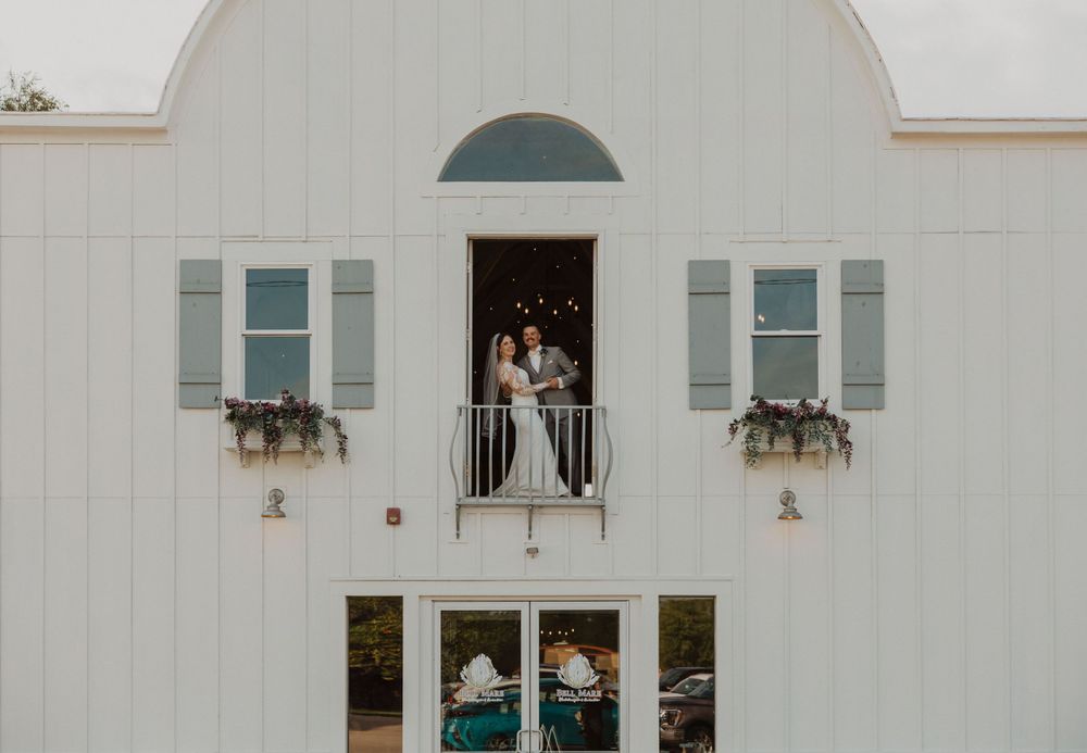 White building exterior featuring arched design elements and decorative window boxes.