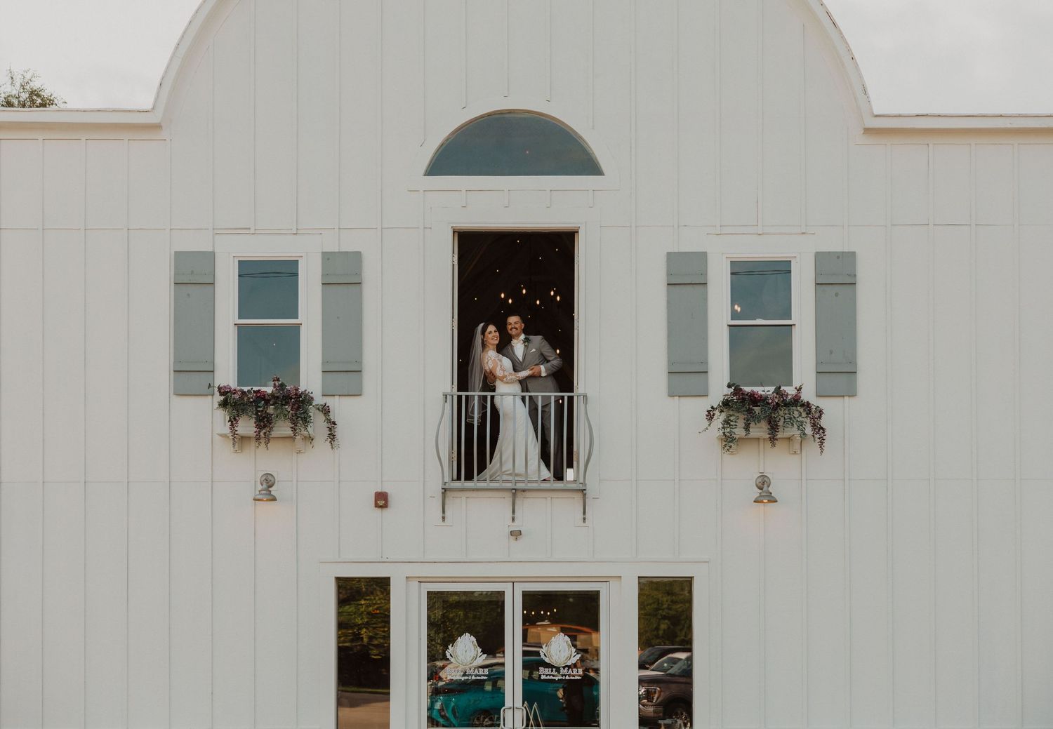 White building exterior featuring arched design elements and decorative window boxes.