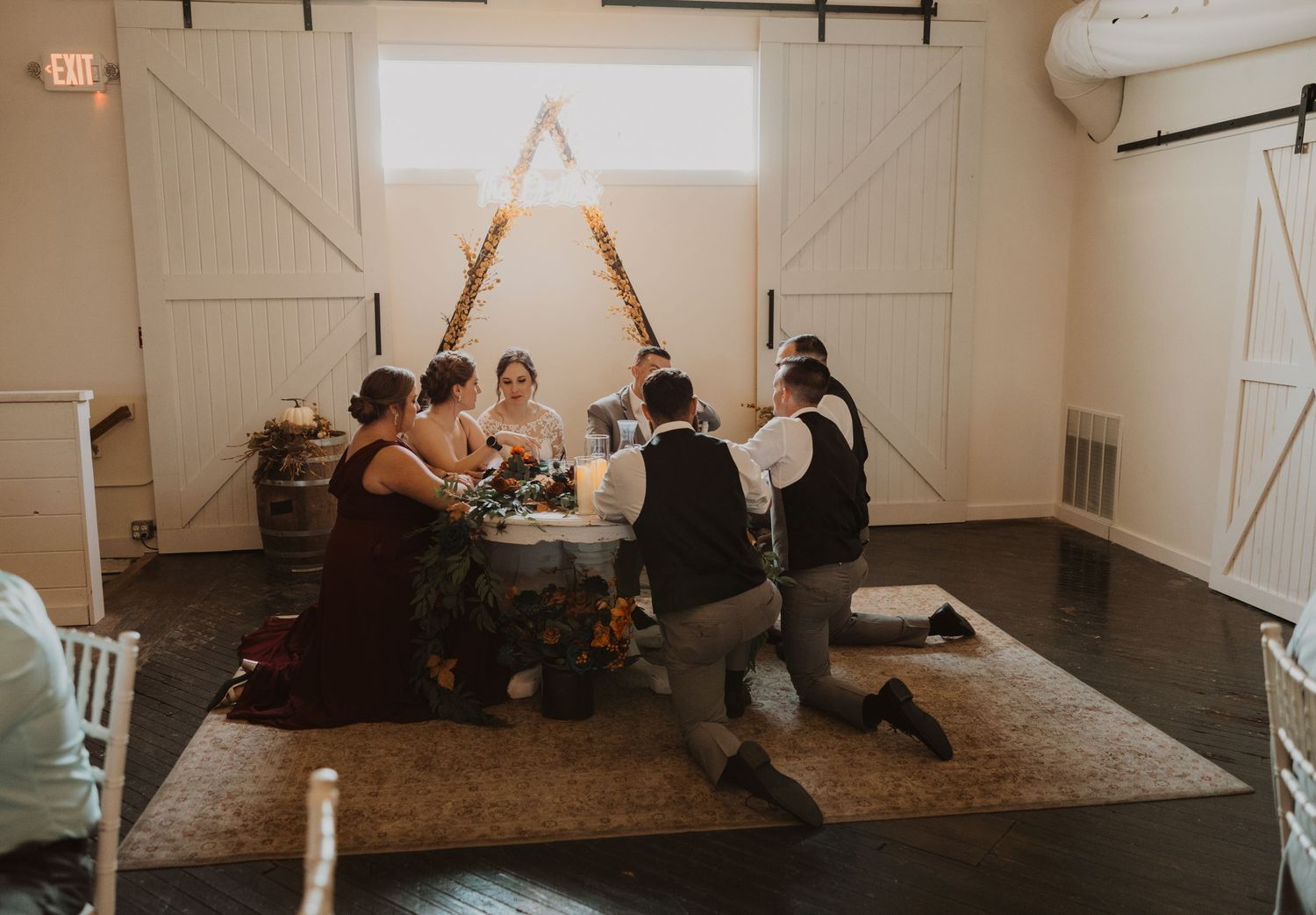 Interior of a rustic barn venue set up for a wedding celebration with chairs and decor.