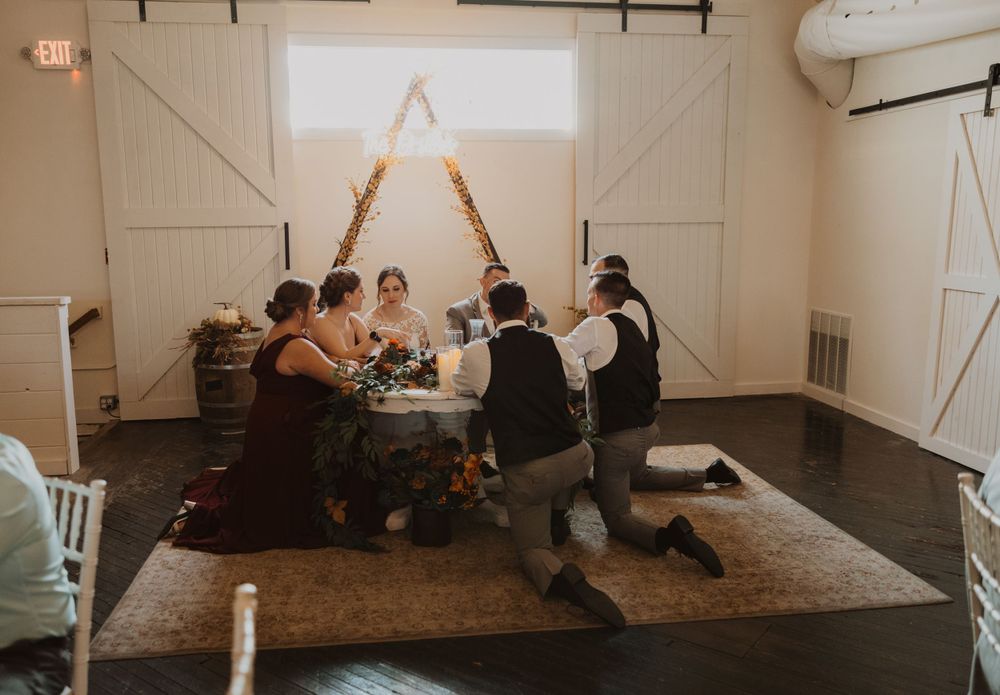 Interior of a rustic barn venue set up for a wedding celebration with chairs and decor.