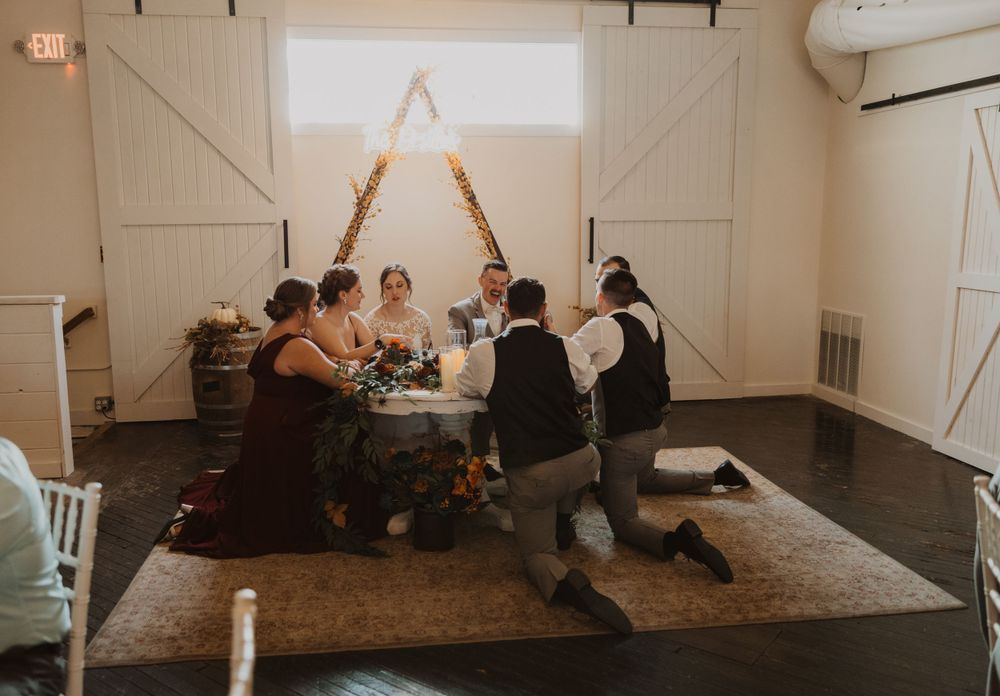 Panoramic view of a barn wedding venue interior with seating and projection screen.