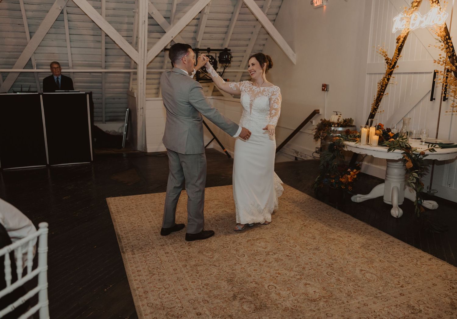 Dancers twirl across a spacious barn venue floor during an intimate wedding celebration.
