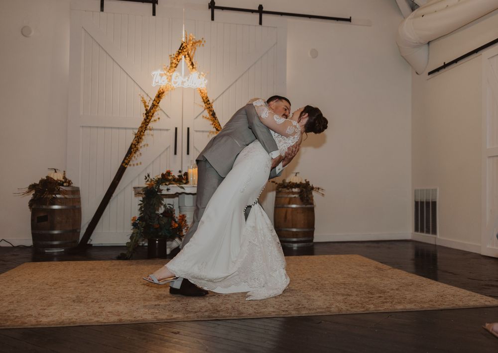 A romantic dance sequence in a rustic venue with exposed wooden beams and warm lighting.