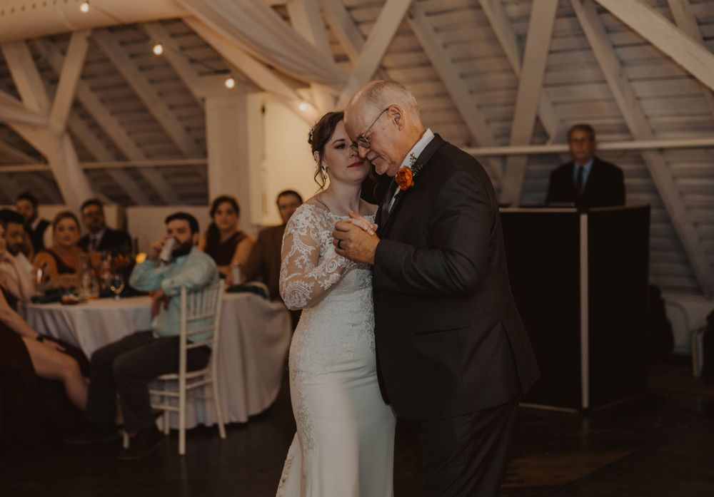 Wedding reception dance floor scene in a beautifully lit barn venue.