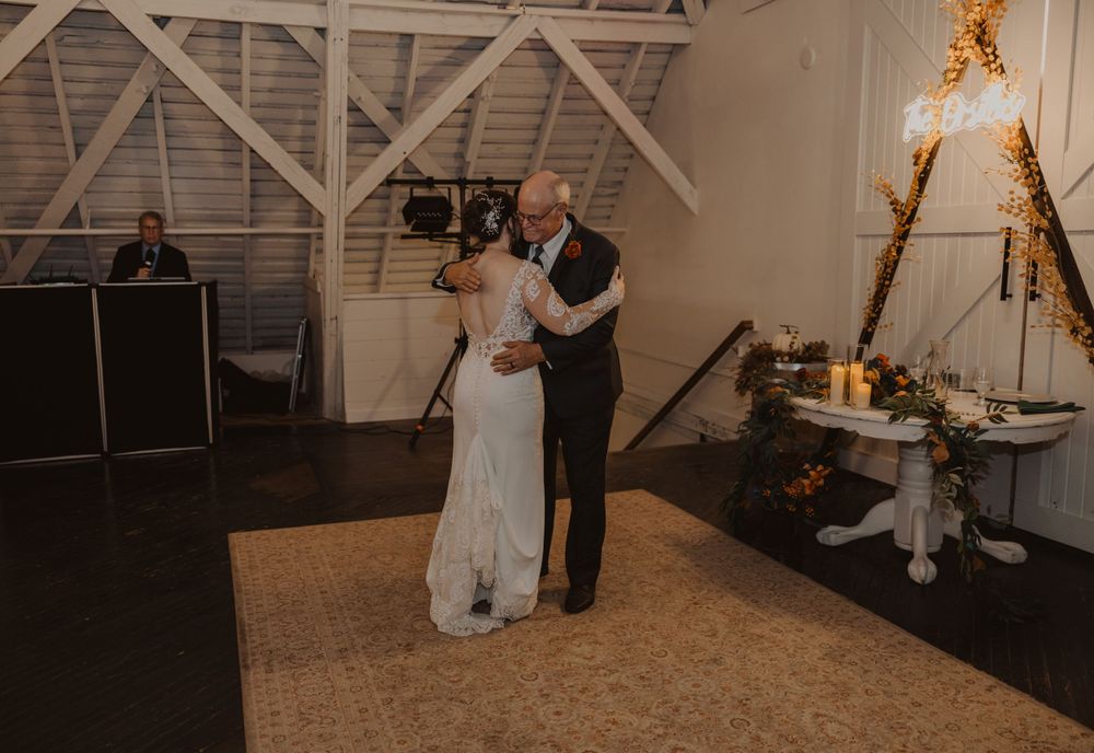 Rustic barn wedding venue decorated with string lights and wooden architectural details.