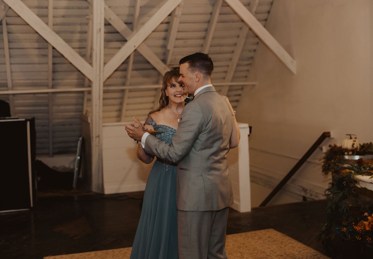 Couples sharing a dance at an intimate wedding reception in a rustic venue.