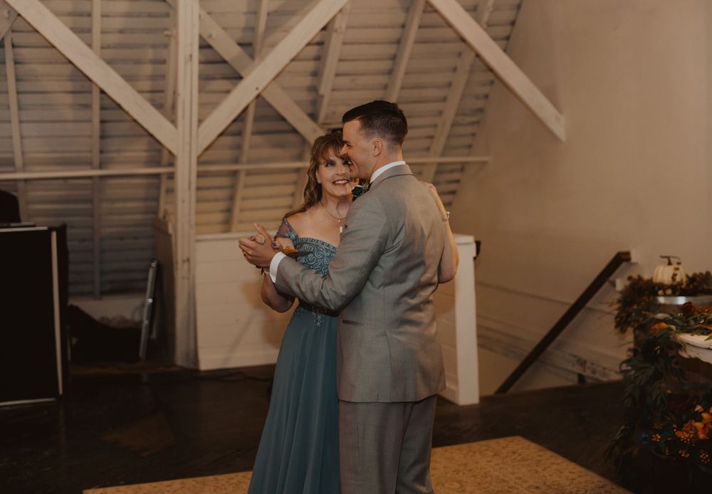 Couples sharing a dance at an intimate wedding reception in a rustic venue.