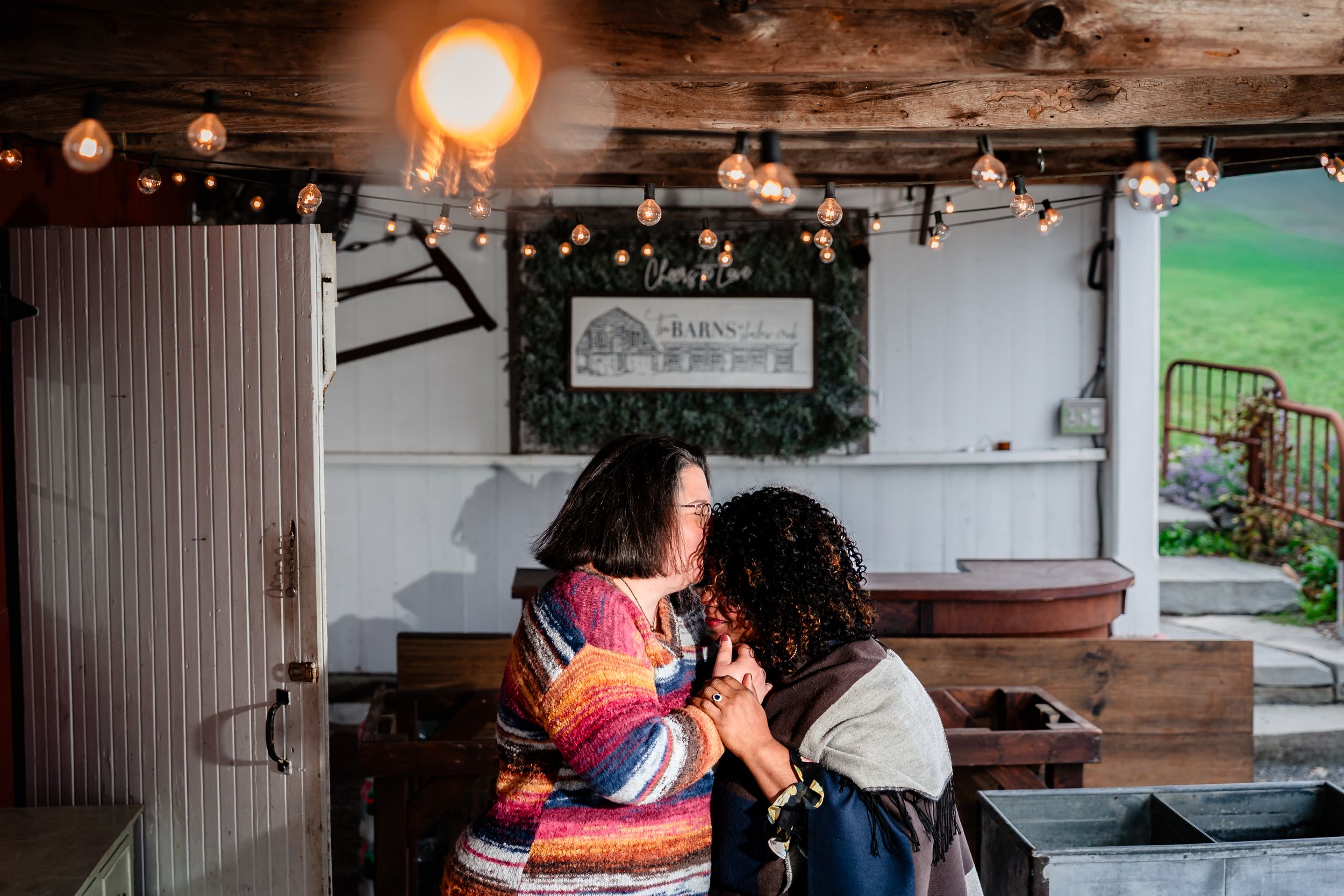 A couple shares a romantic moment at a rustic restaurant with warm lighting and wooden decor.
