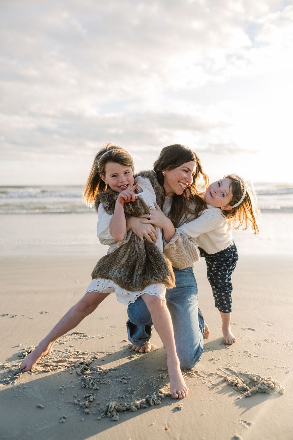 A joyful sequence of playful moments captured on a sunny beach as people laugh and tumble in the sand together.