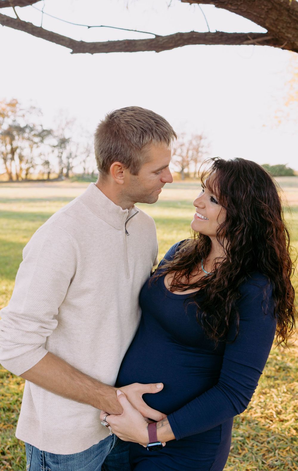True West Photography - Couple embraces intimately against natural outdoor setting during photo session.