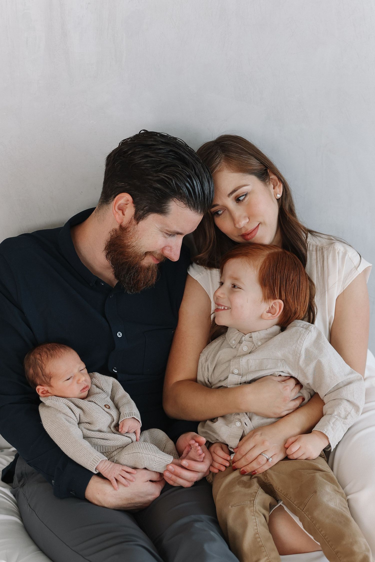 Candid family newborn photos showing older siblings snuggling their new baby brother in California