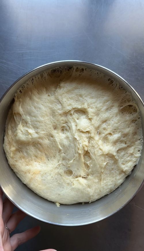 Time-lapse sequence showing bread dough rising in a metal bowl over several stages.
