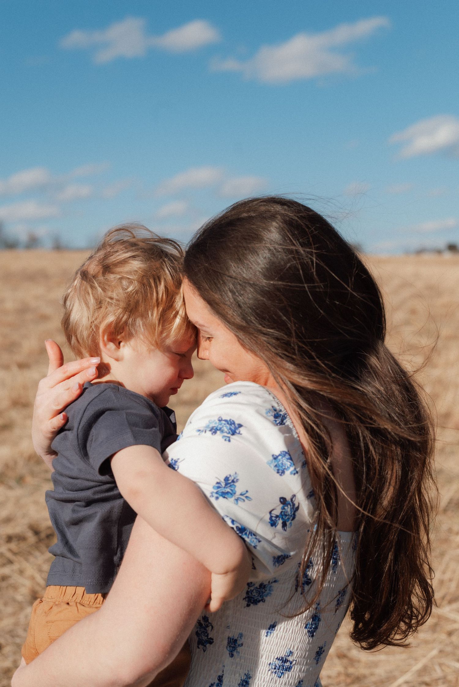 A series of candid family photos taken against a rustic white wooden wall background.