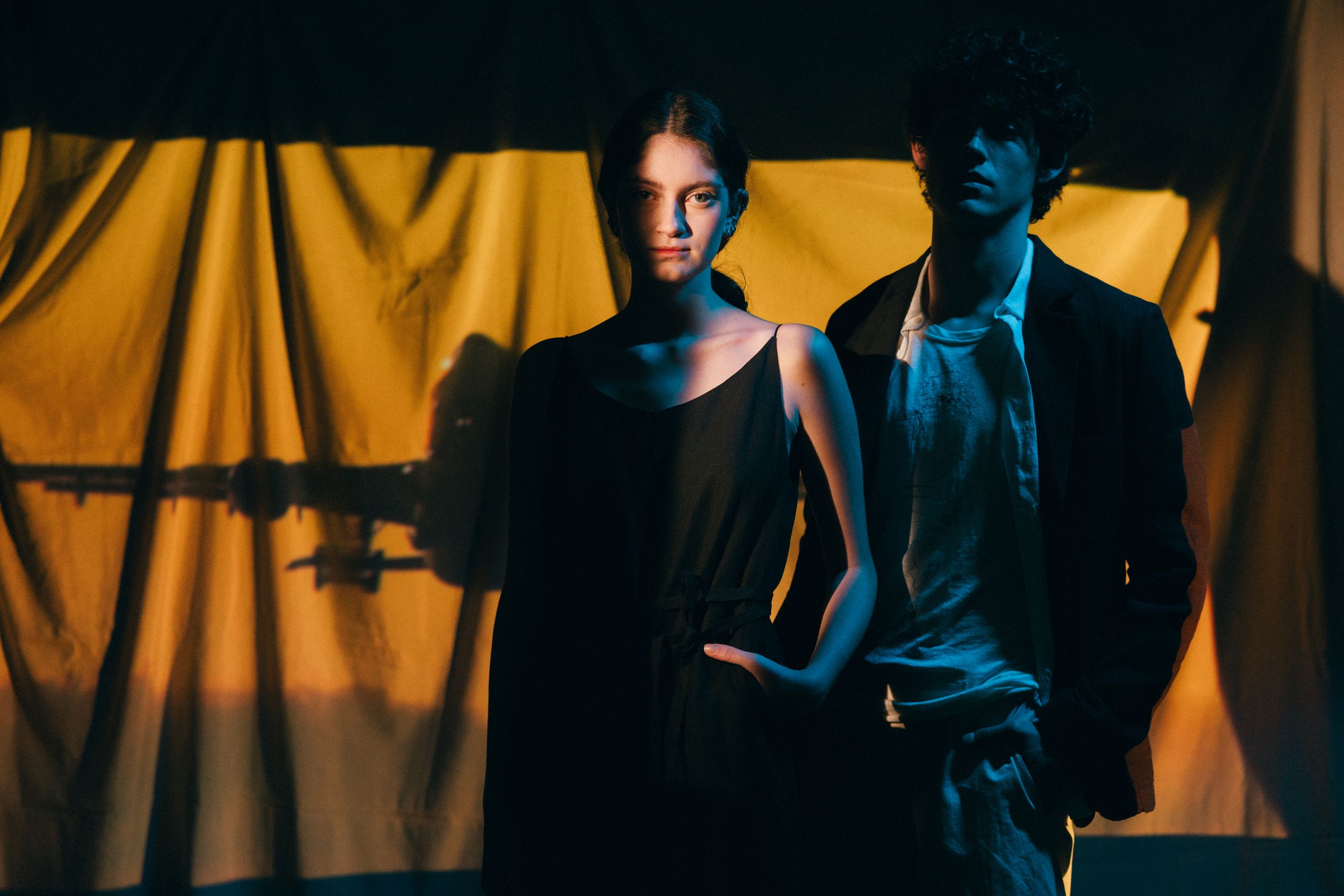 A dramatic sequence of five noir-style photos showing figures in silhouette against a yellow backdrop with moody lighting.