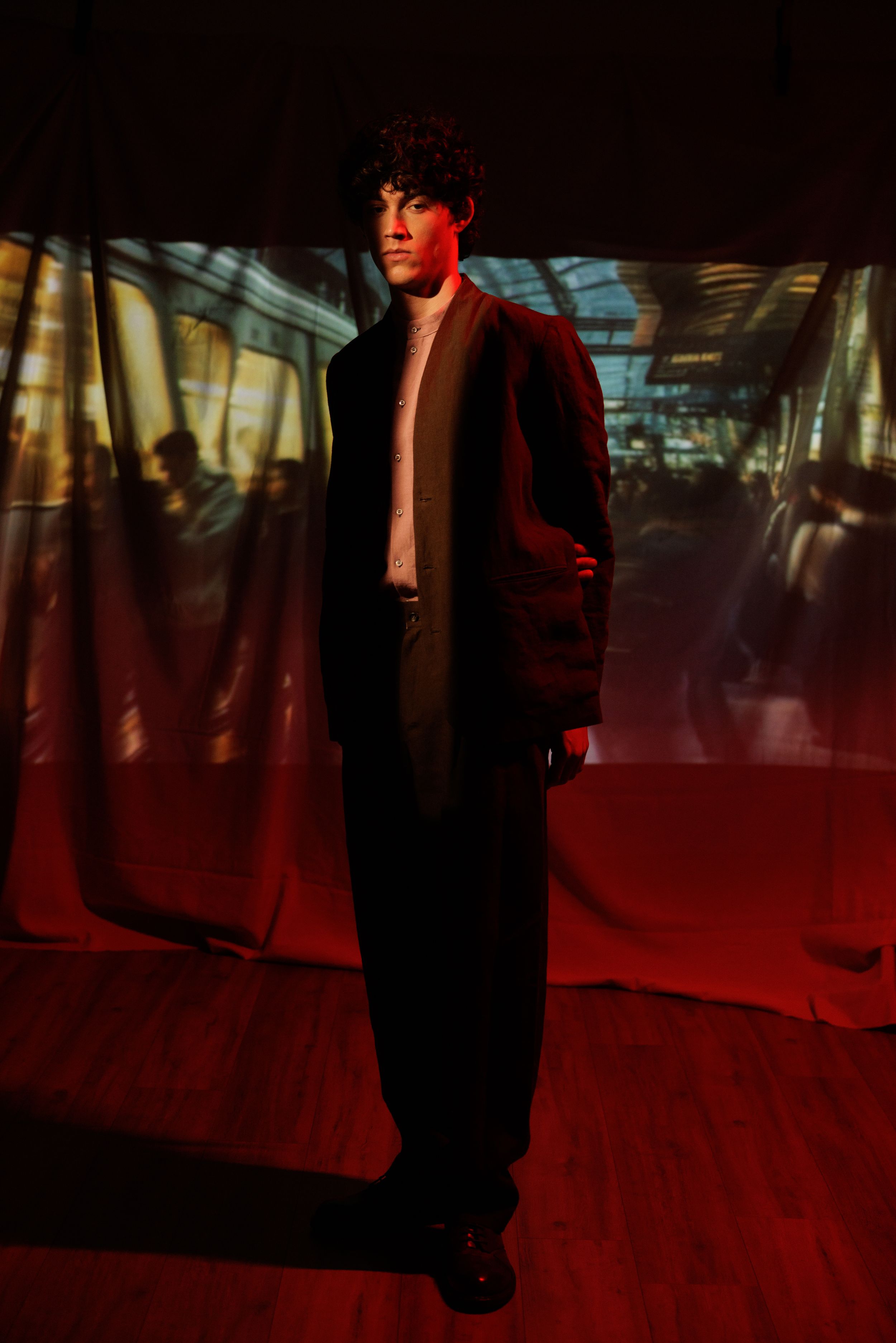 Series of moody cinematic shots showing a figure in black clothing moving through a red-lit space.