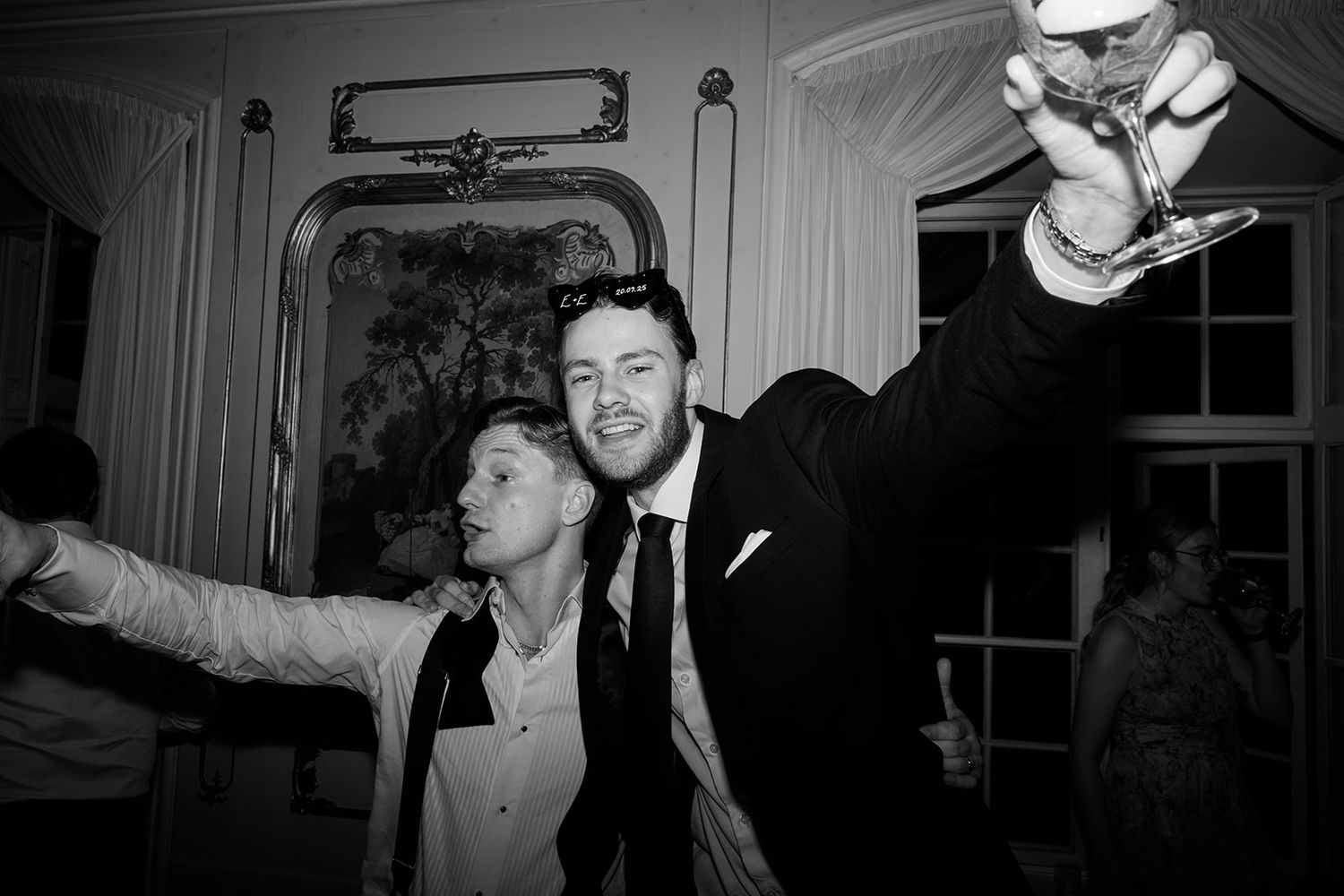 Black and white photo of a group of people in formal attire at what appears to be a social gathering or party.