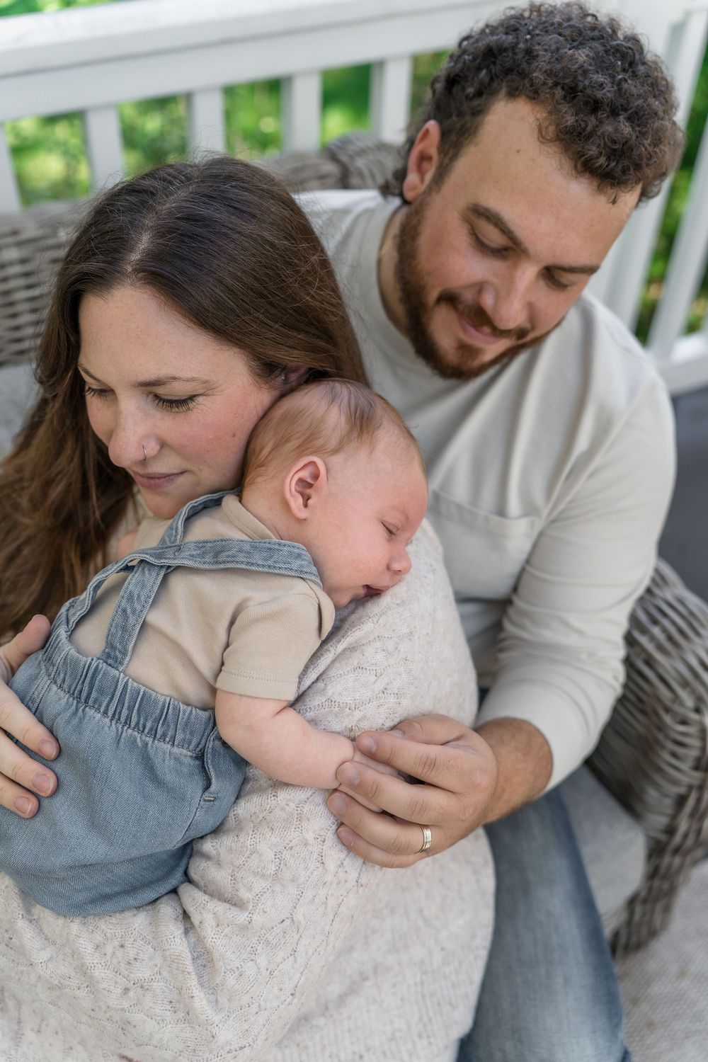Series of intimate family moments showing parents holding and cuddling with a baby wearing denim overalls in Macedonia, Ohio in-home photos