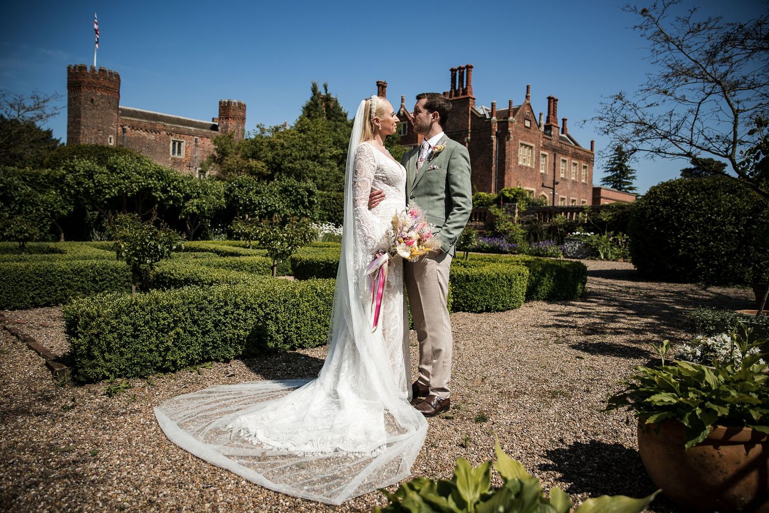 Bride and groom in the stunning gardens at Hodsock Priory with the Priory in the background.