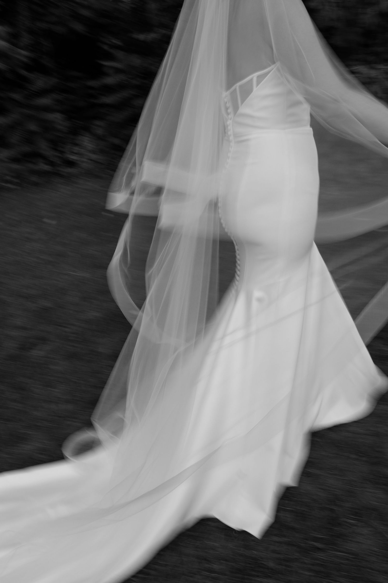 Abstract motion blur of white fabric or dress flowing against dark background creates ethereal effect.