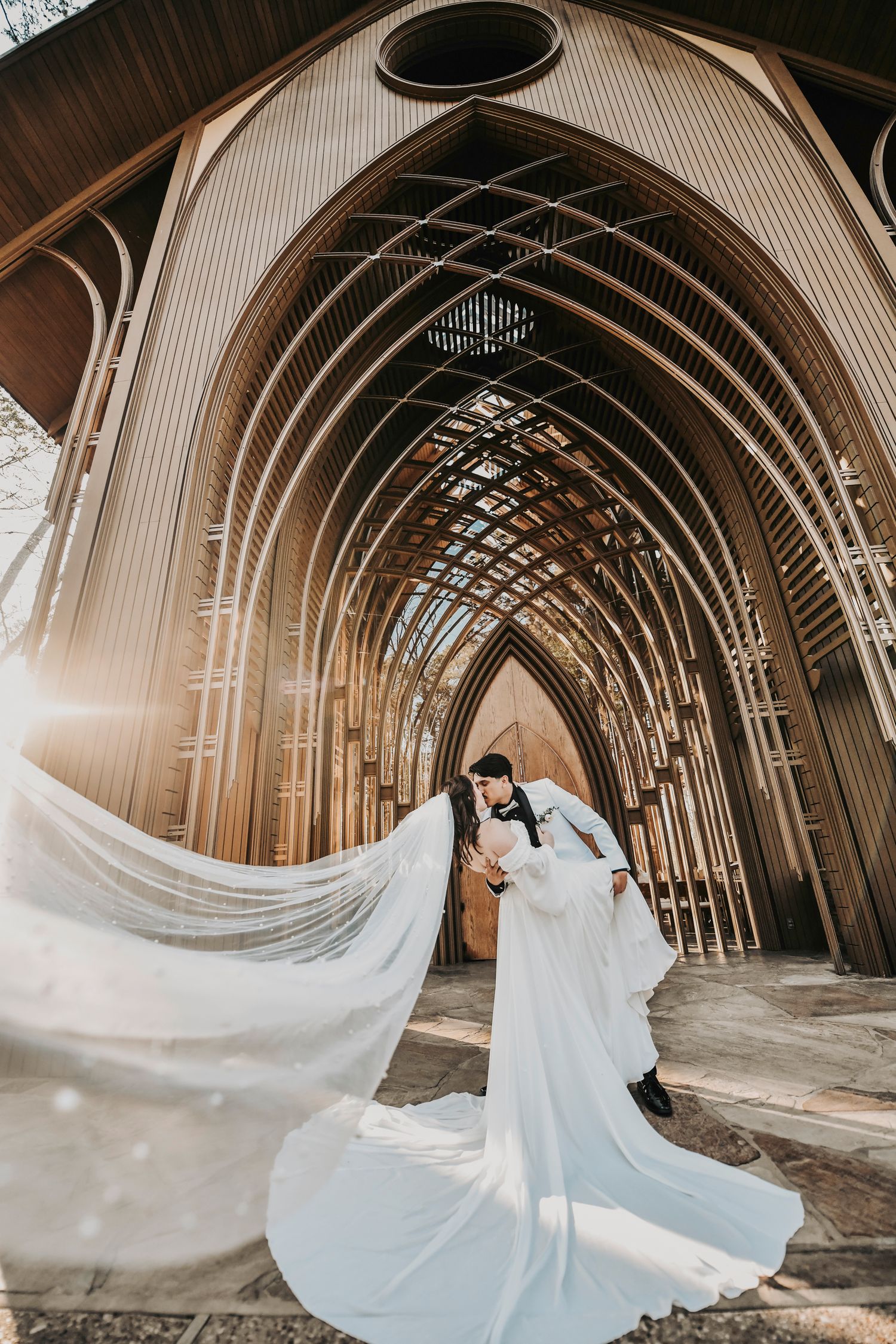 Romantic wedding photo of a couple sharing a dipped kiss