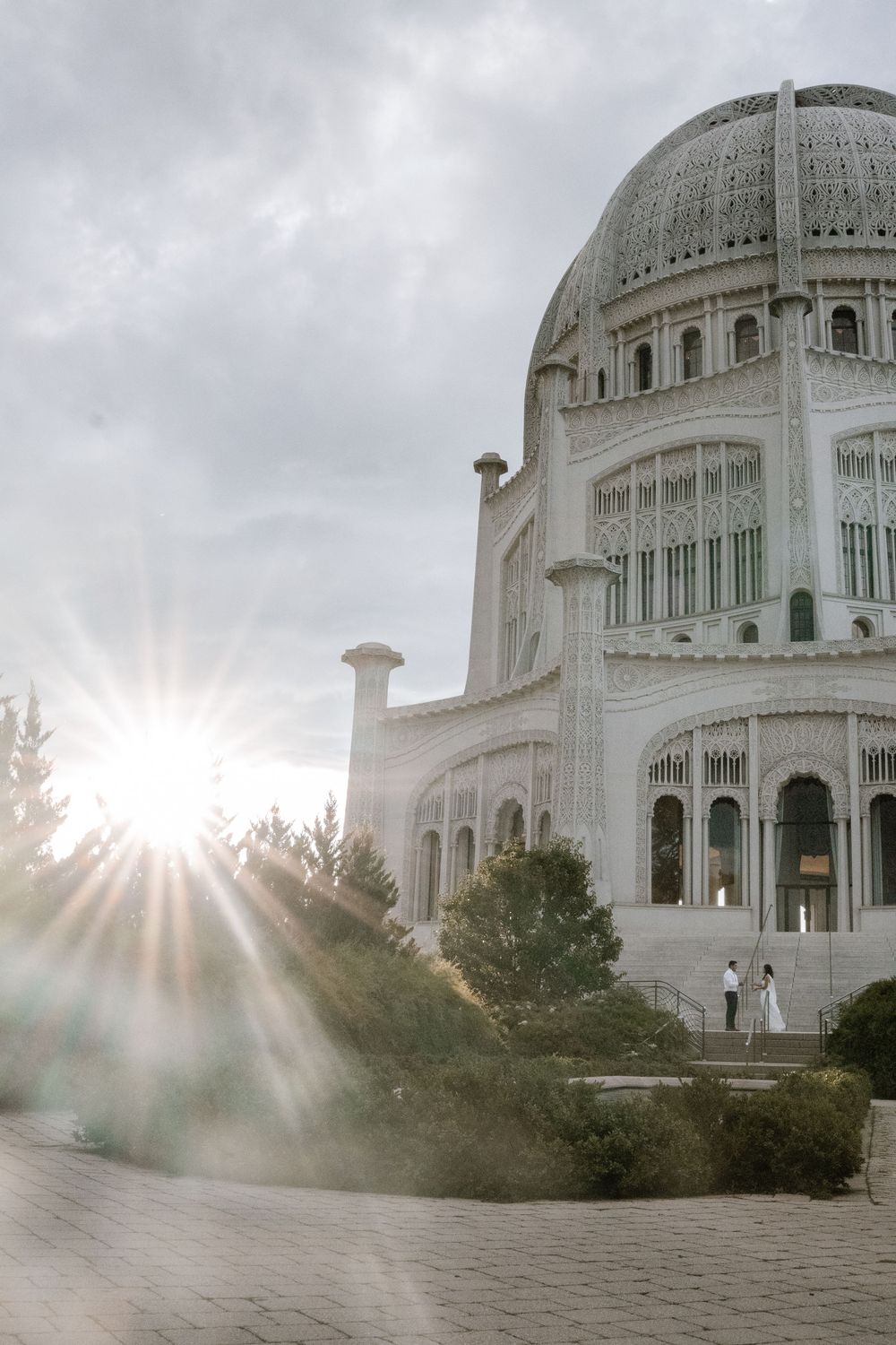 Sun rays shine through the ornate white domed architecture of the Baha'i House of Worship in Wilmette, Illinois.