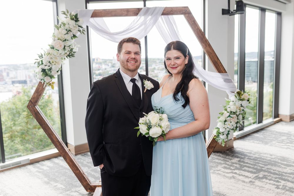 A bridal couple laughs and celebrates together during their wedding celebration in a light-filled indoor setting.