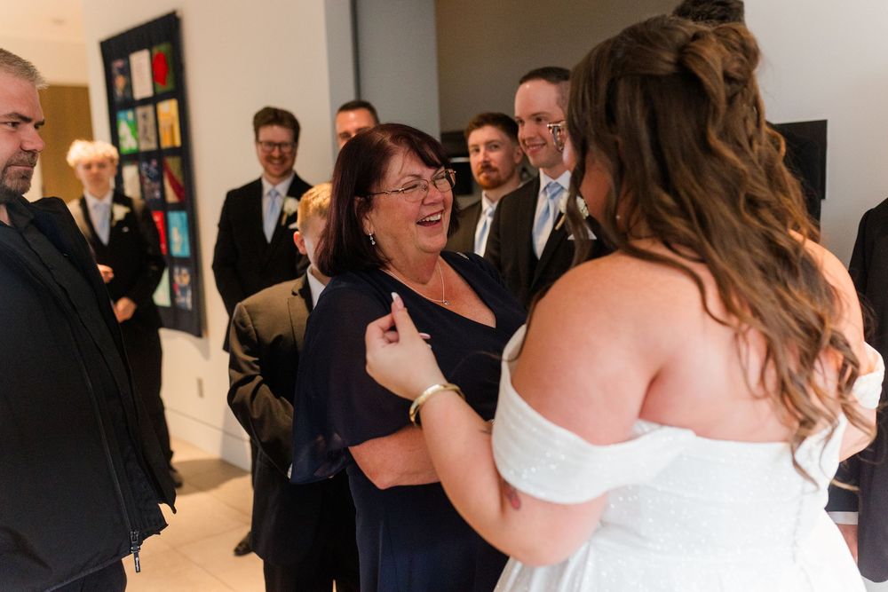 Wedding guests dancing and celebrating together at a reception party inside a venue.