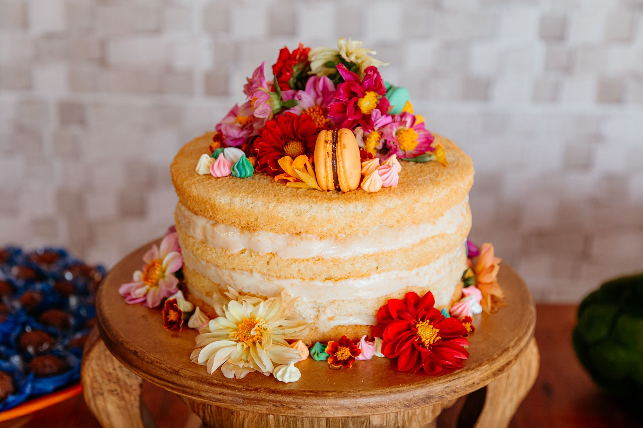 A collage of rustic naked wedding cakes decorated with fresh colorful flowers and simple natural garnishes.
