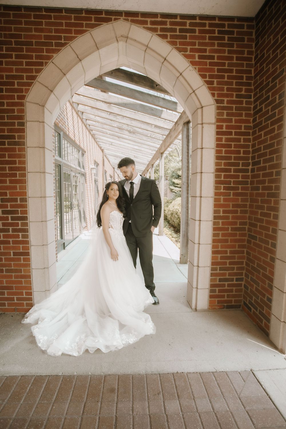 Dancing bride and groom create dynamic motion shots in an elegant brick colonnade.