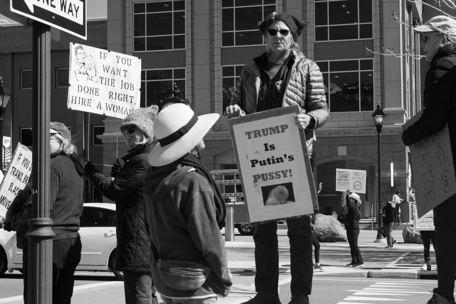 Black and white protest photo featuring a sign reading Trump Is Putins Pussy near Nevada Legislature.