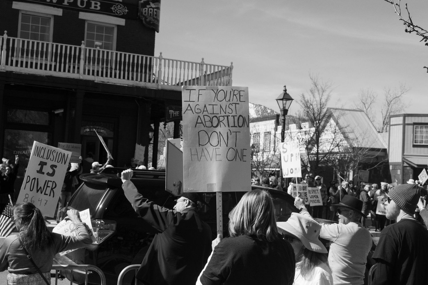 Crowd of protesters holding signs including Total Against Abortion Don't Have One at outdoor rally.