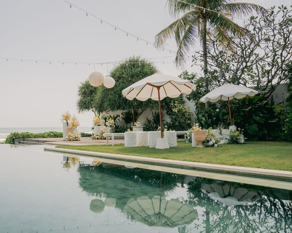 A luxurious infinity pool with tropical palm trees reflects the serene landscape at sunset creating a tranquil oasis.