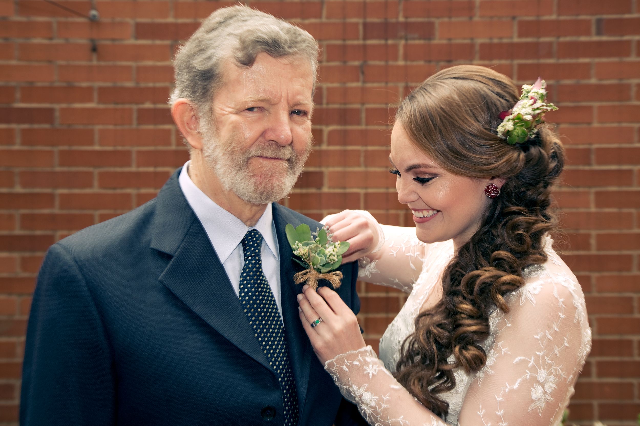 A bride fixes her father's dress on her wedding day.