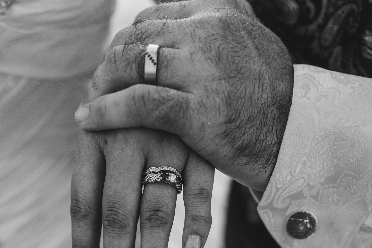 Series of black and white close-up shots showing hands with wedding rings.