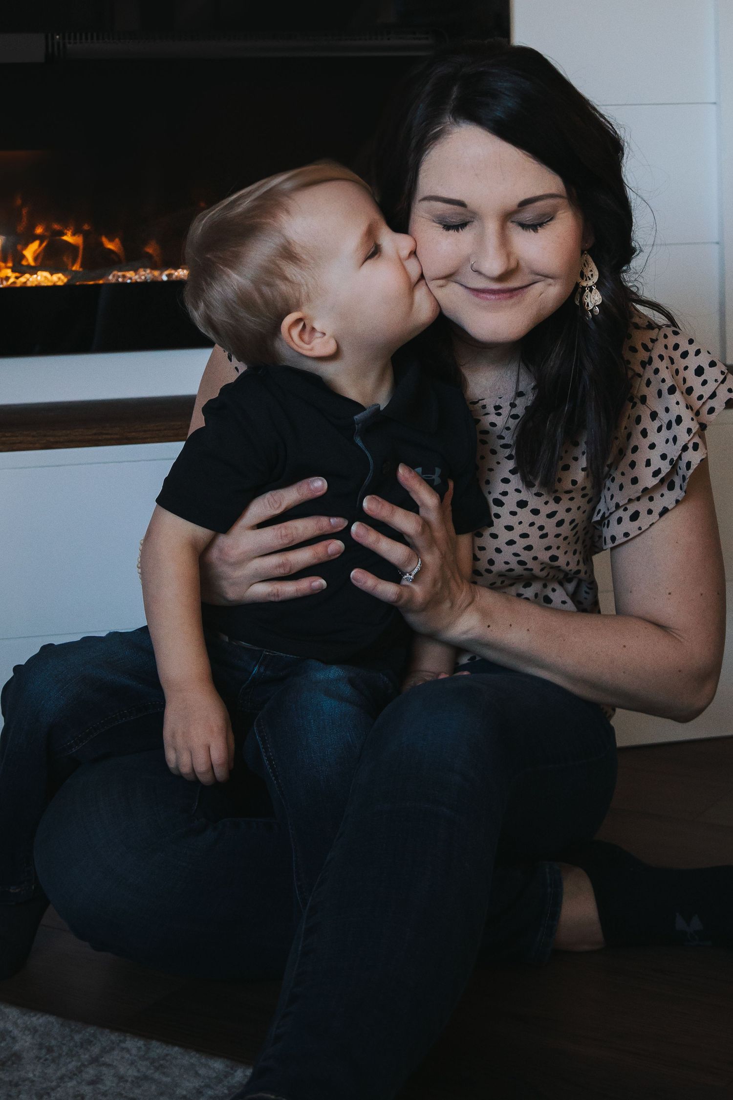 Intimate family moment captured in low light with child and parent sharing tender embrace.