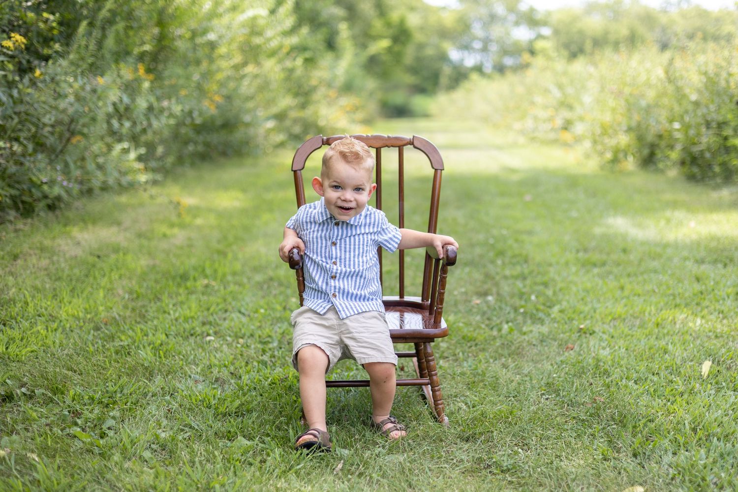 Springfield, IL Photographer captures a boy smiling on a chair during a milestone session in Central, IL