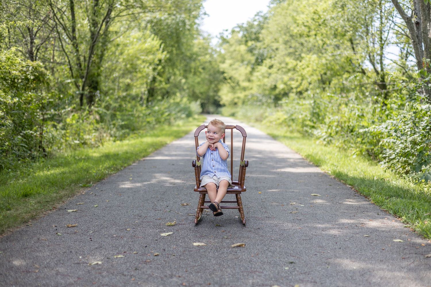 Springfield, IL Photographer captures a boy smiling with his hands folded during a milestone session in Central, IL