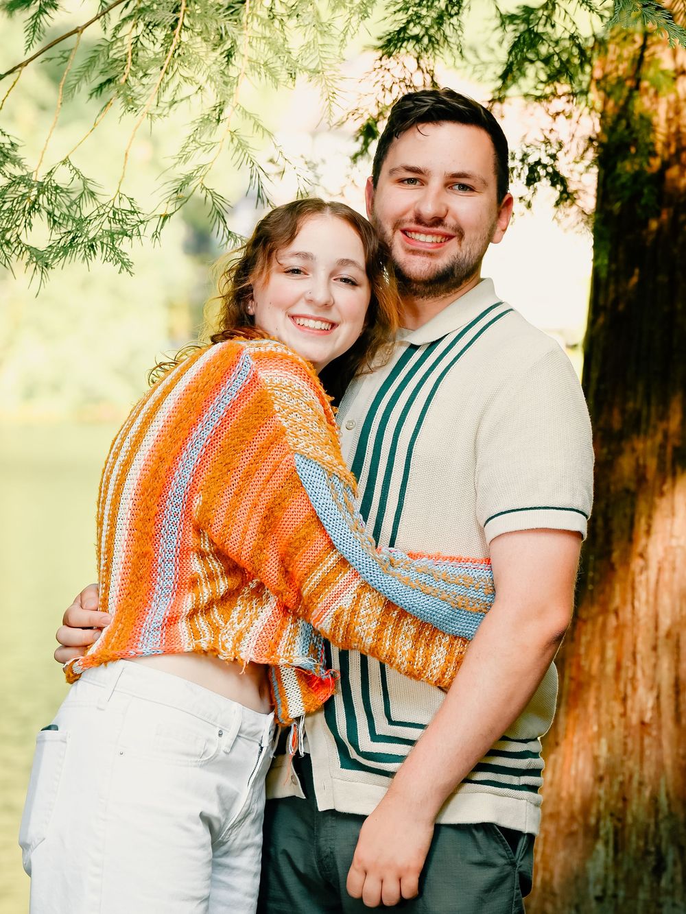 Couples pose for cheerful outdoor portraits wearing casual attire with orange and striped accents.