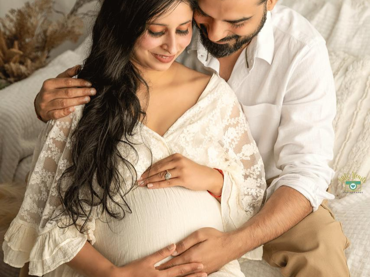 A couple shares tender moments in white lace and cotton outfits during an intimate photoshoot.