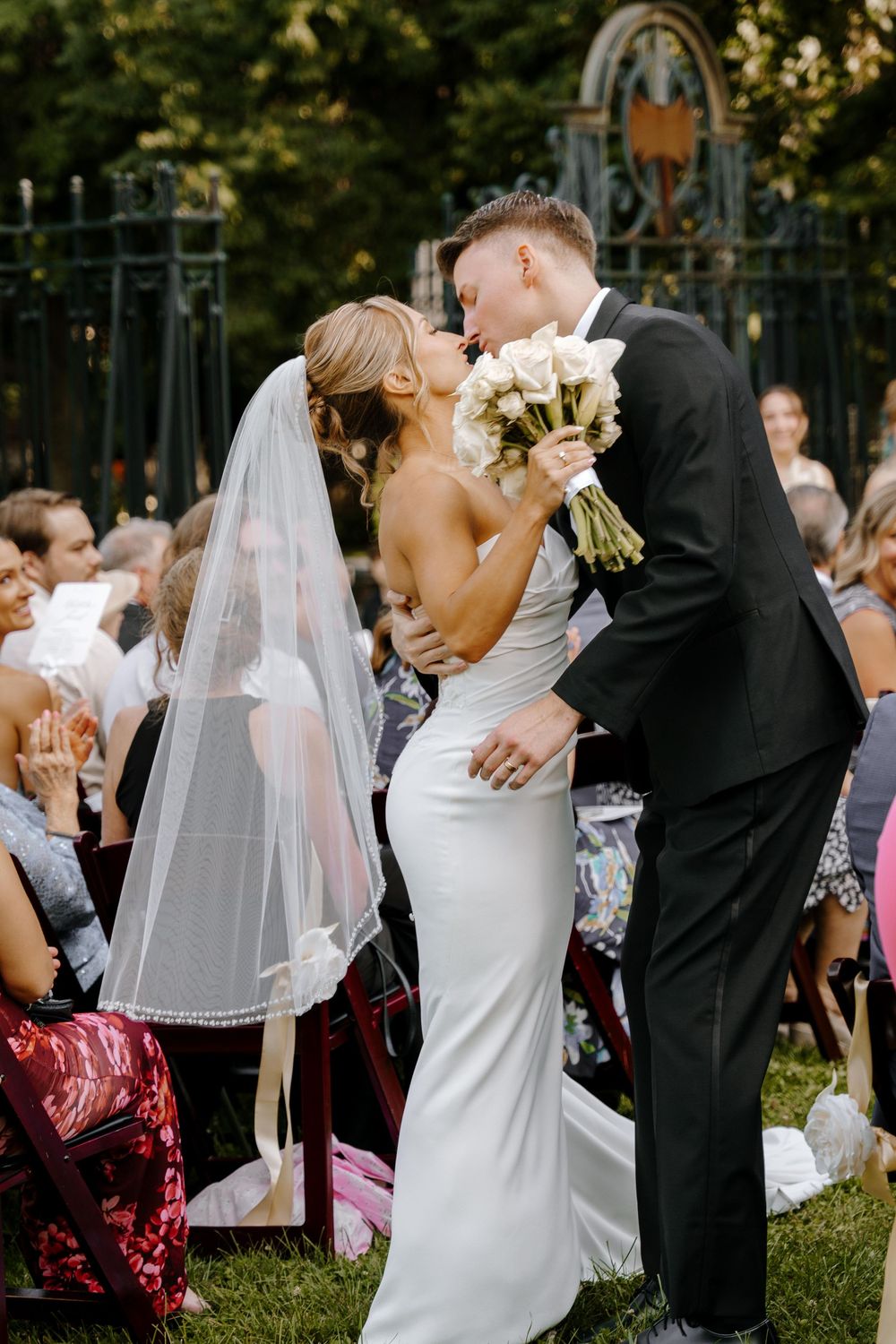 Wedding couple shares romantic kisses in a sequence of candid outdoor ceremony moments.