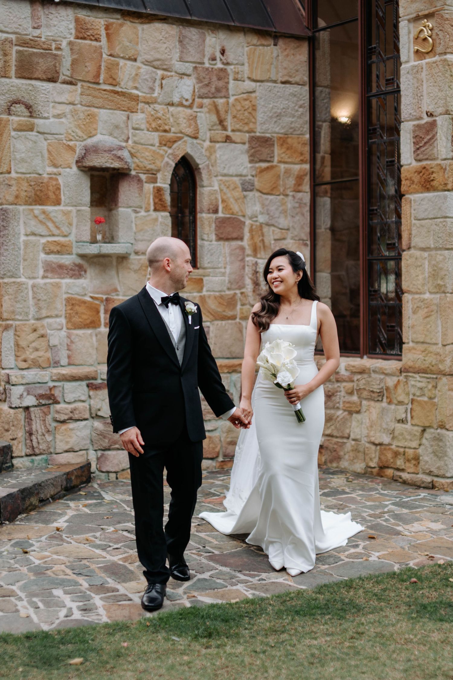 A wedding couple shares candid moments in a series of four photos against a rustic stone wall backdrop.