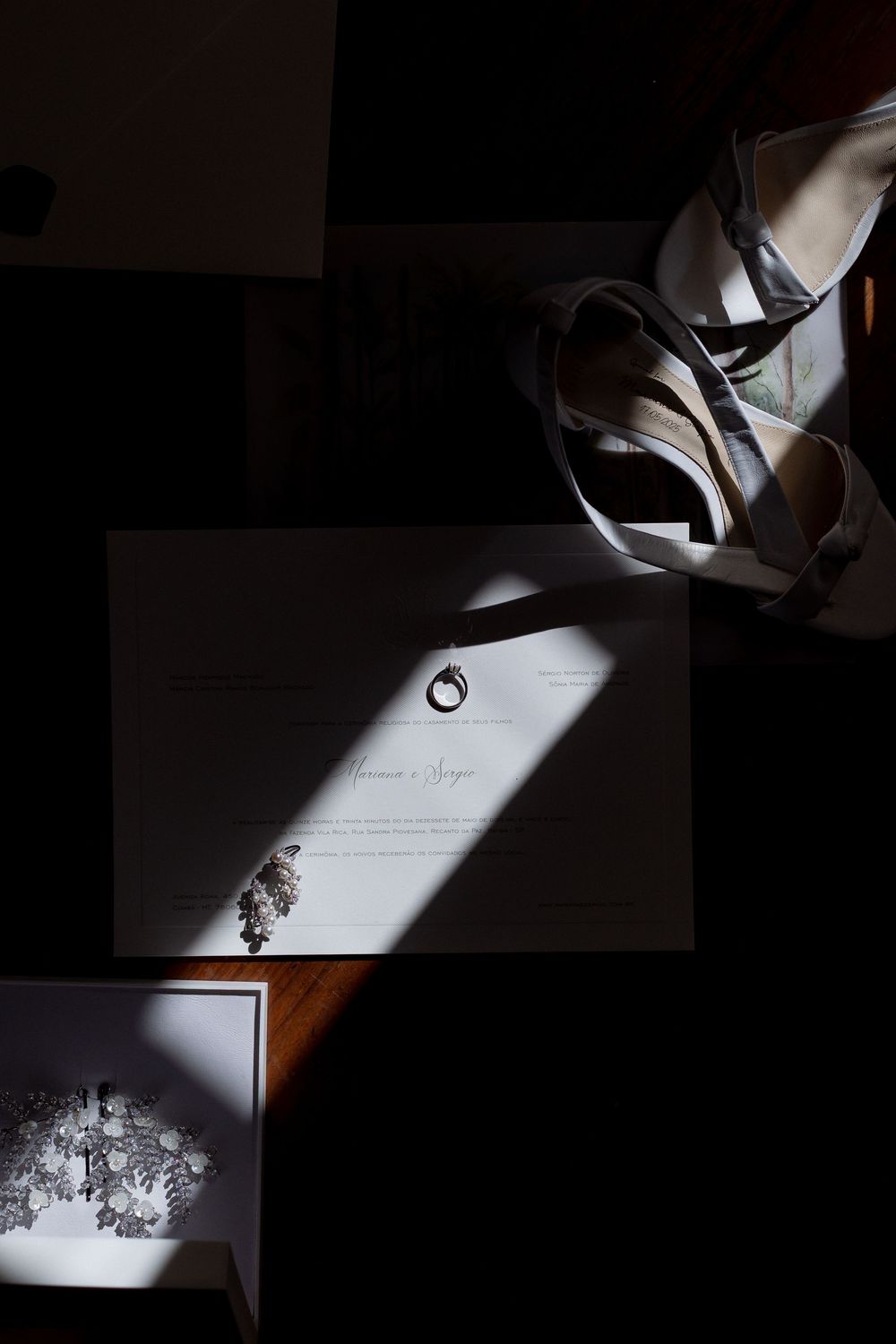 Gentle sunlight casts artistic shadows across a paper document laying on a dark surface.