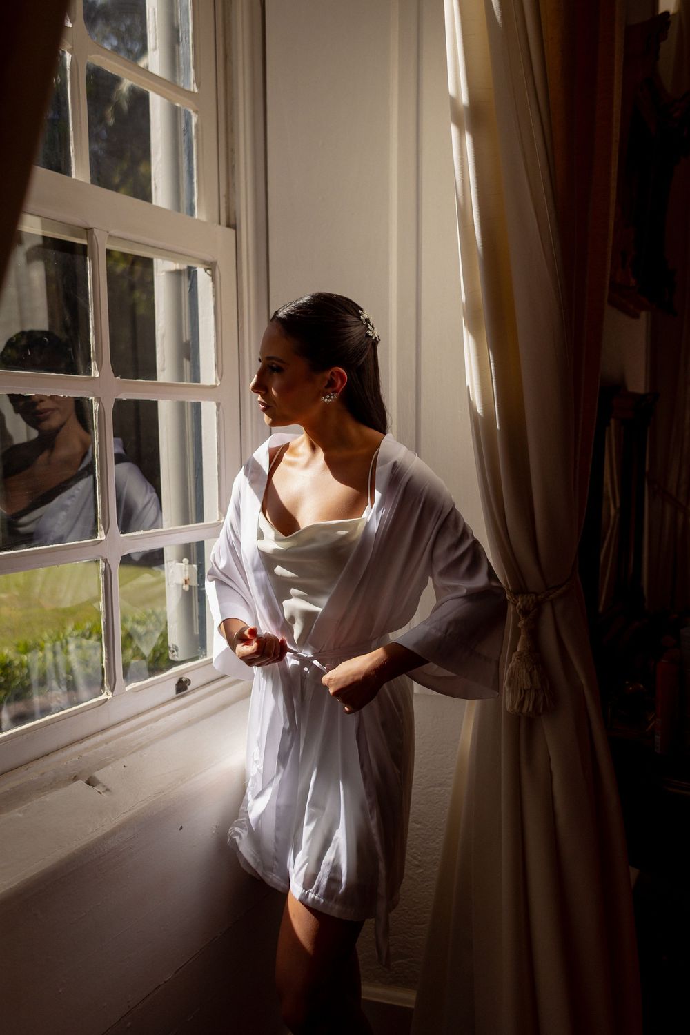 A sequence of photos shows a person leaning from a window and closing curtains in warm natural light.