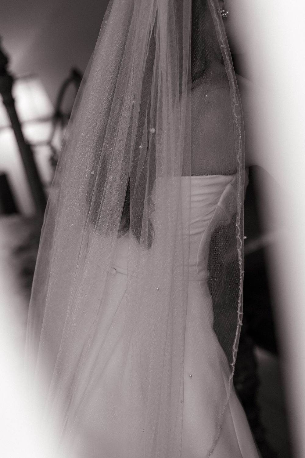 A bride in a white wedding gown with flowing veil shown in a series of dreamlike black and white photographs.